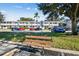 Apartment exterior view with a bus stop bench, and cars parked in front of the building at 8080 112Th St # 108, Seminole, FL 33772