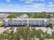 Aerial view of the white three-story condo and its manicured grounds and convenient parking at 8080 112Th St # 108, Seminole, FL 33772
