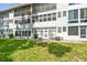 Low-angle exterior view of the white condo building showing its well-maintained lawn and multiple windows at 8080 112Th St # 108, Seminole, FL 33772