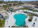 Aerial view of a kidney-shaped community pool with blue umbrellas and chairs in a spacious courtyard at 8080 112Th St # 108, Seminole, FL 33772