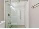 This bathroom has a gorgeous shower with sliding glass doors and white marble-look tile at 8080 112Th St # 108, Seminole, FL 33772