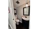 Small, updated bathroom with dark vanity, built-in storage, and hardwood floors at 8100 Dr Martin Luther King Jr N St # 202, St Petersburg, FL 33702