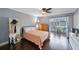 Cozy bedroom featuring hardwood floors, ceiling fan, and access to an outdoor patio at 8100 Dr Martin Luther King Jr N St # 202, St Petersburg, FL 33702