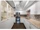 Bright kitchen with white cabinets, mosaic backsplash, granite counters, and stainless steel appliances at 8100 Dr Martin Luther King Jr N St # 202, St Petersburg, FL 33702