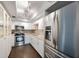 Bright kitchen with white cabinets, mosaic backsplash, granite counters, and stainless steel refrigerator at 8100 Dr Martin Luther King Jr N St # 202, St Petersburg, FL 33702
