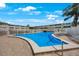 Clean community pool with ladder surrounded by a fence and lounge chairs at 8100 Dr Martin Luther King Jr N St # 202, St Petersburg, FL 33702