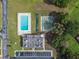 Aerial view of the community pool, shuffleboard courts, parking, and surrounding trees at 8447 Orleans N, Pinellas Park, FL 33781