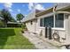 Home's backyard featuring well-kept lawn, patio with room for seating, and lush landscaping at 8447 Orleans N, Pinellas Park, FL 33781