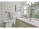 Bathroom with patterned wallpaper, white vanity, and glass-enclosed shower at 8447 Orleans N, Pinellas Park, FL 33781