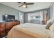 Cozy bedroom featuring wood floors, ceiling fan, and TV with an ensuite bathroom at 8447 Orleans N, Pinellas Park, FL 33781