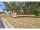 Entrance to Vendome Village features a brick and stucco sign surrounded by lush greenery at 8447 Orleans N, Pinellas Park, FL 33781