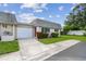 Charming home featuring a well-manicured lawn, red door, and attached garage on a sunny day at 8447 Orleans N, Pinellas Park, FL 33781