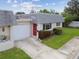 Charming home with a well-maintained lawn, a red front door, and a gray roof at 8447 Orleans N, Pinellas Park, FL 33781