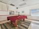 Game room with a pool table covered in a red cloth and decorated with a geometric rug and window at 8447 Orleans N, Pinellas Park, FL 33781