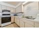 Kitchen featuring an oven, neutral cabinets, essential appliances, and an accent countertop at 8447 Orleans N, Pinellas Park, FL 33781