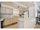 Eat-in kitchen featuring an island, neutral cabinets, essential appliances and an accent countertop at 8447 Orleans N, Pinellas Park, FL 33781