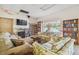 A lounge with cozy couches, bookshelves, and a television overlooking a pool area at 8447 Orleans N, Pinellas Park, FL 33781