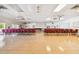 A meeting room featuring ample seating with rows of tables and red chairs and multiple ceiling fans at 8447 Orleans N, Pinellas Park, FL 33781