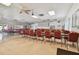 A meeting room featuring ample seating with rows of tables and red chairs and multiple ceiling fans at 8447 Orleans N, Pinellas Park, FL 33781