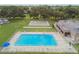 Aerial view of a community pool and recreational area surrounded by mature trees and well-maintained grounds at 8447 Orleans N, Pinellas Park, FL 33781