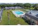 Community outdoor swimming pool with lounge chairs, flagpole, and shuffleboard courts in a well-maintained lawn setting at 8447 Orleans N, Pinellas Park, FL 33781