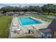 Aerial view of a community pool with lounge chairs and tables, next to building and bocce ball court at 8447 Orleans N, Pinellas Park, FL 33781