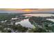 Breathtaking aerial view of the property surrounded by lush greenery and a serene lake at sunset at 8515 Macoma Ne Dr, St Petersburg, FL 33702