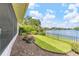 Lakeside backyard featuring a well-maintained lawn, garden beds, and a fence bordering the tranquil water at 8515 Macoma Ne Dr, St Petersburg, FL 33702