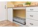 Custom-designed dog area features comfortable bedding, and built-in cabinets in the laundry room at 8515 Macoma Ne Dr, St Petersburg, FL 33702