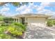 Inviting front yard with well-manicured landscaping, lush greenery, and a spacious driveway at 8515 Macoma Ne Dr, St Petersburg, FL 33702