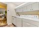 Well-equipped laundry room with a sink, washer, and dryer plus a doorway to another room at 8515 Macoma Ne Dr, St Petersburg, FL 33702