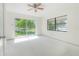 Bright bedroom with large windows, ceiling fan, and view of the lush outdoors at 8701 Driftwood Drive Dr, Tampa, FL 33615