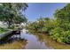 Scenic view of a tranquil canal with lush foliage along the banks and a private boat dock at 8701 Driftwood Drive Dr, Tampa, FL 33615