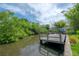 View of private wooden dock, offering access to serene waters surrounded by lush greenery at 8701 Driftwood Drive Dr, Tampa, FL 33615