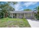 Charming single-story home with inviting front porch, well-kept lawn, and classic architectural details at 8701 Driftwood Drive Dr, Tampa, FL 33615