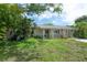 Charming single-story home with inviting front porch, lush landscaping, and freshly manicured lawn at 8701 Driftwood Drive Dr, Tampa, FL 33615