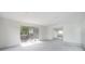 Bright, open living room featuring light gray floors, sliding glass doors to the outdoor patio, and neutral paint at 8701 Driftwood Drive Dr, Tampa, FL 33615