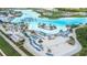 Stunning aerial shot of a resort-style pool area with sandy beaches, lounge chairs, and tropical landscaping at 9098 Forge Breeze Loop, Wesley Chapel, FL 33545