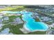 Expansive aerial view of a community lagoon, amenities, and new home construction at 9098 Forge Breeze Loop, Wesley Chapel, FL 33545