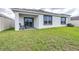 Spacious backyard with a covered patio and a sliding glass door, ideal for outdoor entertaining at 9098 Forge Breeze Loop, Wesley Chapel, FL 33545