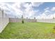 Large, grassy backyard enclosed with a mix of white and tan fencing, perfect for recreation and relaxation at 9098 Forge Breeze Loop, Wesley Chapel, FL 33545