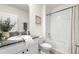 Bathroom with a stylish granite countertop, a white vanity, and a bathtub with shower at 9098 Forge Breeze Loop, Wesley Chapel, FL 33545