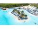 Gorgeous aerial view of a community lagoon with beach, tiki huts and lounge chairs at 9098 Forge Breeze Loop, Wesley Chapel, FL 33545