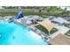 Aerial view of a community pool with a large waterslide, lounge chairs and picnic area at 9098 Forge Breeze Loop, Wesley Chapel, FL 33545