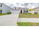 Charming single-story home showcasing a well-manicured lawn, neutral paint scheme, and attached two-car garage at 9098 Forge Breeze Loop, Wesley Chapel, FL 33545