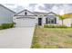 Charming single-story home showcasing a well-manicured lawn, neutral paint scheme, and attached two-car garage at 9098 Forge Breeze Loop, Wesley Chapel, FL 33545