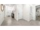 Bright hallway featuring tile flooring, neutral walls, and access to multiple rooms at 9098 Forge Breeze Loop, Wesley Chapel, FL 33545