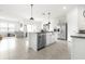 Open-concept kitchen featuring stainless steel appliances, white cabinetry, and an island with barstool seating at 9098 Forge Breeze Loop, Wesley Chapel, FL 33545