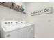 Bright laundry room with a Whirlpool washer and dryer and ample shelving for storage at 9098 Forge Breeze Loop, Wesley Chapel, FL 33545