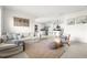 Cozy living room with tile flooring, neutral walls, comfortable seating, and an open layout leading to the kitchen at 9098 Forge Breeze Loop, Wesley Chapel, FL 33545